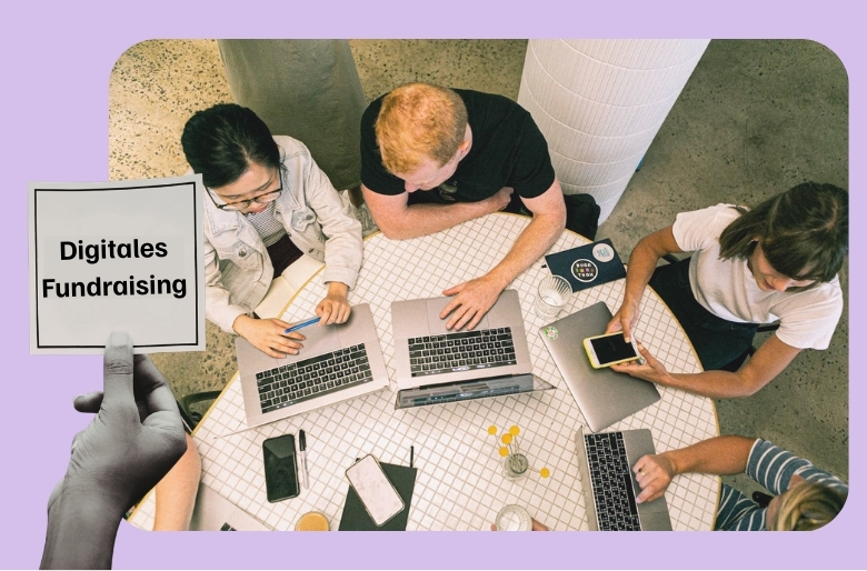 Hand hält Schild welches sagt digitales Fundraising. Im Hintergrund sitzen Menschen am Tisch vor Laptop.